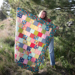 Charm square quilt with quilter in nature