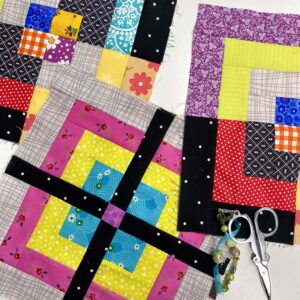 A group of scrappy quarter log cabin blocks