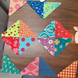 Scrappy fabric triangles in bright colors arranged into diamonds