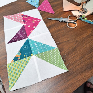 Half square triangles arranged into flying geese to make arrows.