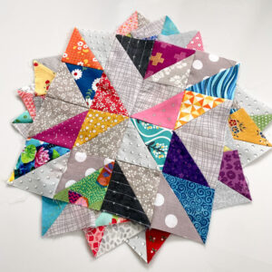Stack of scrappy half square triangle blocks with gray background