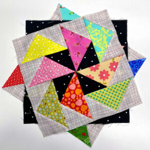 Stack of quilt blocks with Dutchmen's puzzle on top