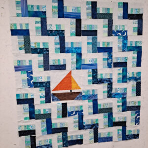 Scrappy rail fence quilt with focus sailboat block