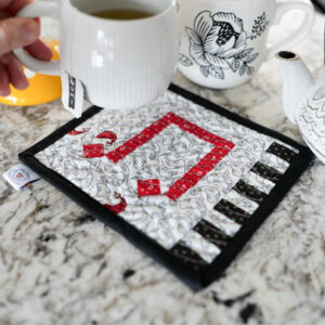 Music mug rug with cup of tea