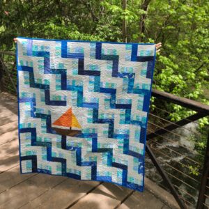 Baby quilt with sailboat on a bridge in the woods