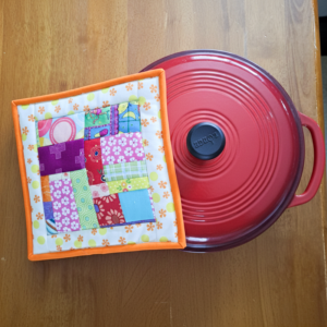 Quilted hot pad from crumb fabric with cast iron pot.