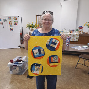 Quilter holding up appliqued crumb quilt circles