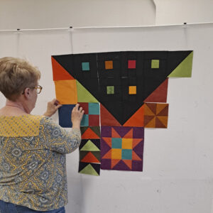 Quilter laying out quilt on design wall