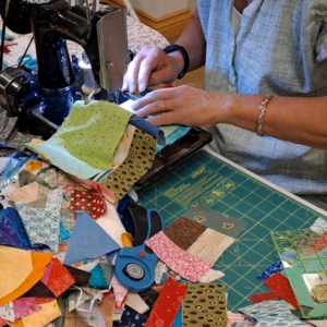 quilter sewing scraps on a feather weight sewing machine 