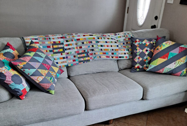 Scrap quilt and throw pillows on couch