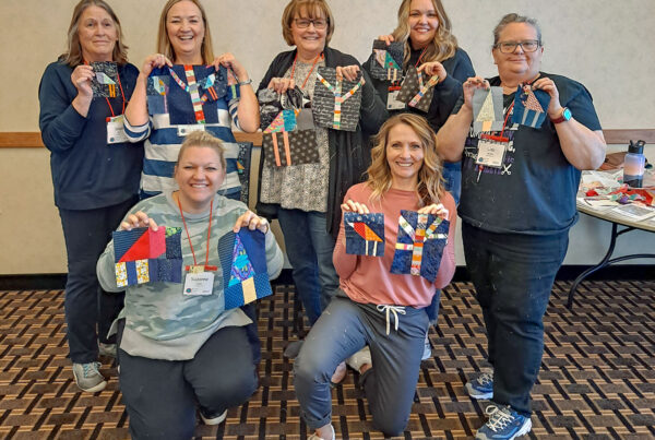 Quilters showing off their wonky quilt blocks from the Enchanted Forest Improv class