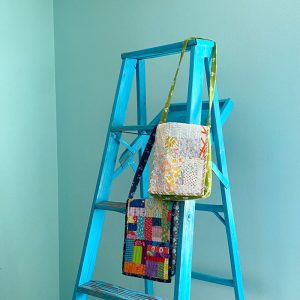 Patchwork purses hanging on a blue ladder