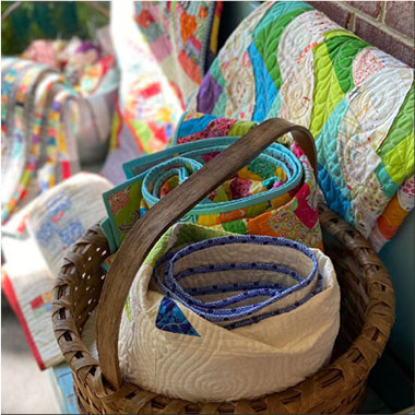 Scrap quilts on a bench and in a basket