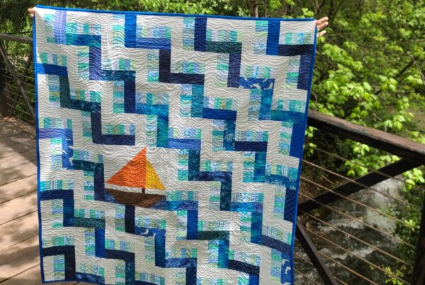 Baby quilt with sailboat on a bridge in the woods