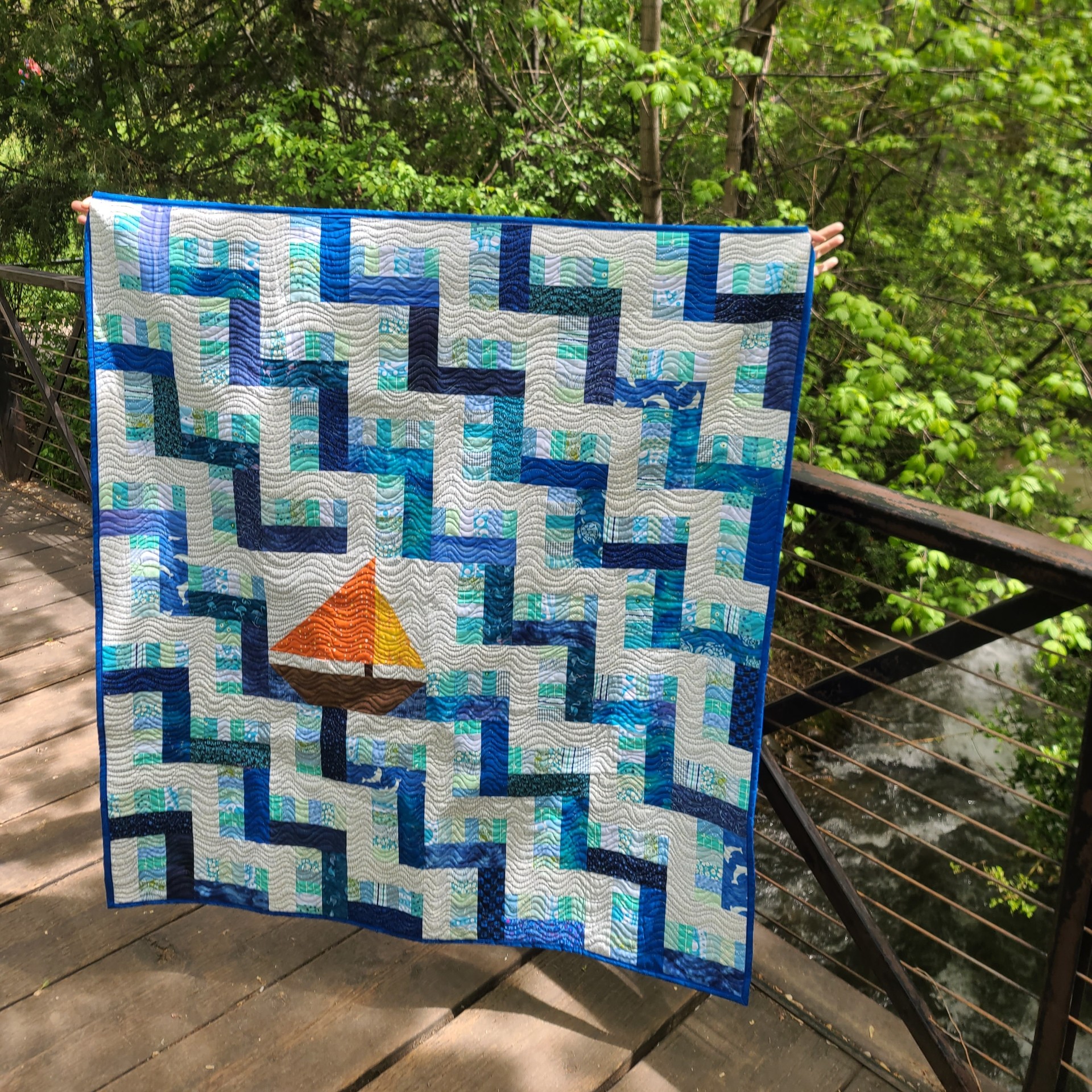 Baby quilt with sailboat on a bridge in the woods