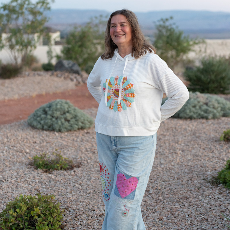 Girl wearing thrifted sweatshirt with applique and upcycled jeans